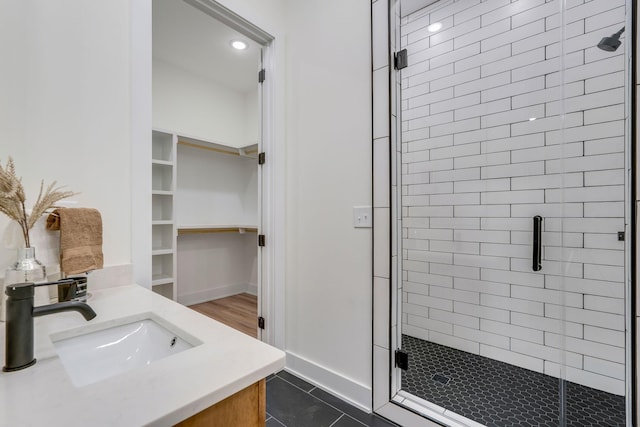 bathroom featuring a shower with door, vanity, and tile patterned flooring