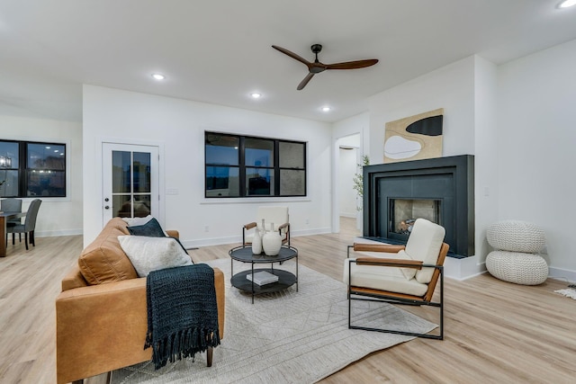 living room with light hardwood / wood-style floors and ceiling fan