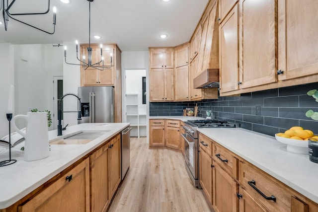 kitchen featuring sink, decorative light fixtures, light hardwood / wood-style floors, stainless steel appliances, and a chandelier