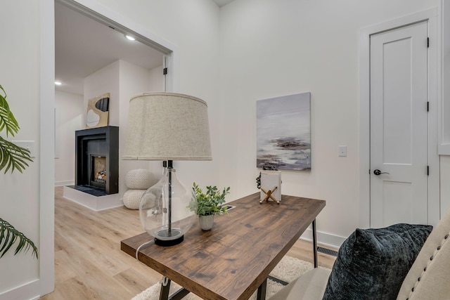 office featuring a fireplace and light hardwood / wood-style floors