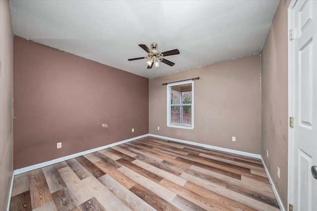 spare room featuring ceiling fan, wood-type flooring, and a textured ceiling