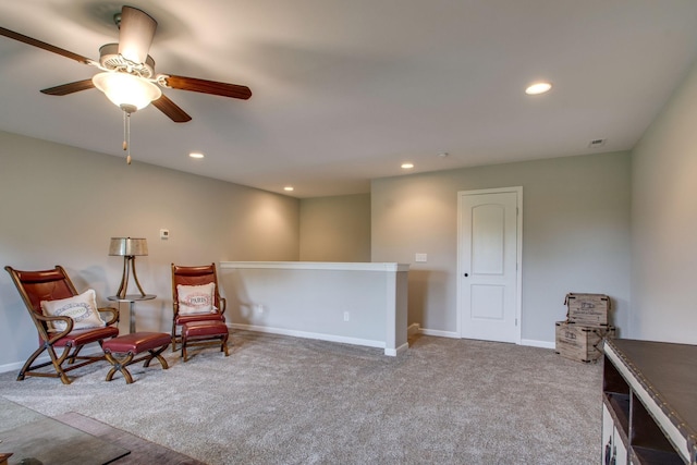 living area featuring light carpet and ceiling fan