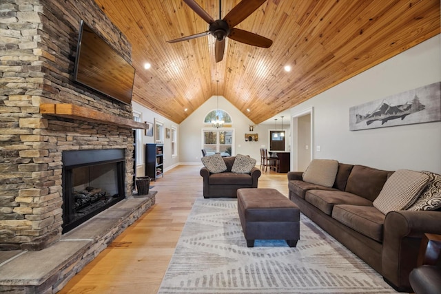 living room with wood ceiling, ceiling fan with notable chandelier, vaulted ceiling, light hardwood / wood-style flooring, and a fireplace