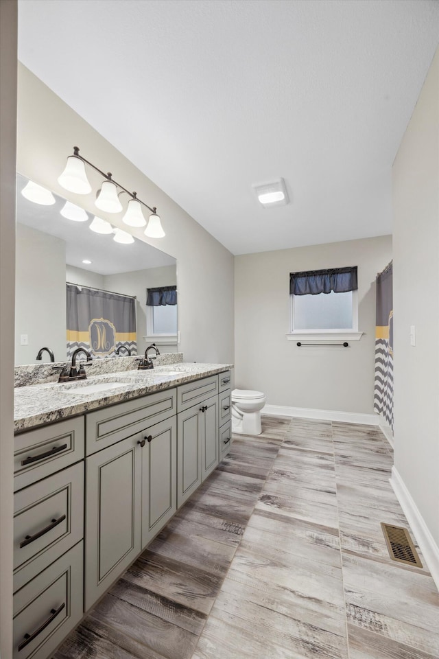 bathroom featuring hardwood / wood-style floors, vanity, and toilet