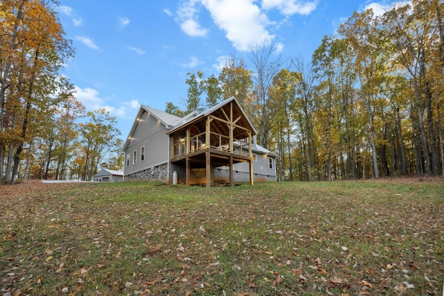 back of house with a wooden deck and a yard