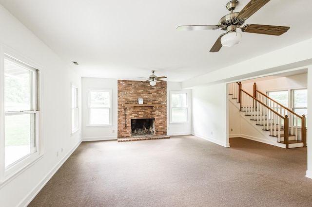 unfurnished living room featuring a fireplace, plenty of natural light, and ceiling fan