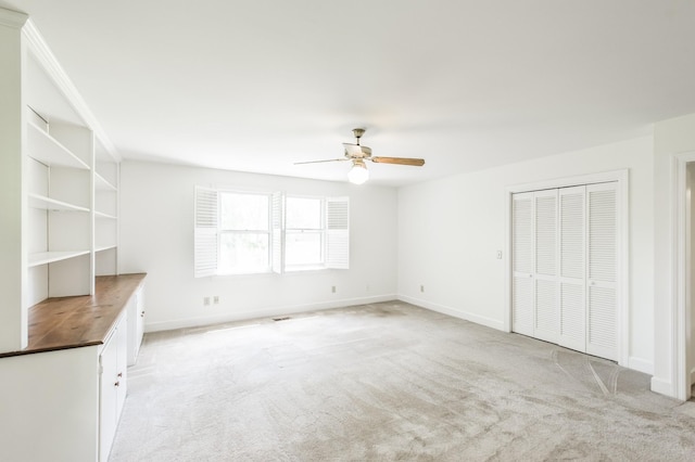 interior space with light colored carpet and ceiling fan