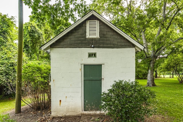 view of outbuilding featuring a lawn