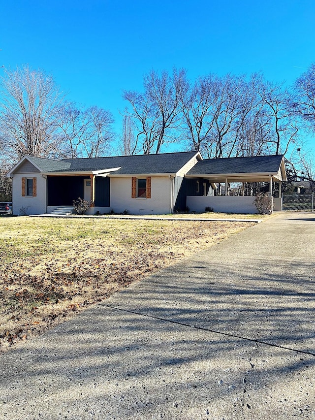 ranch-style house featuring a front lawn and a carport