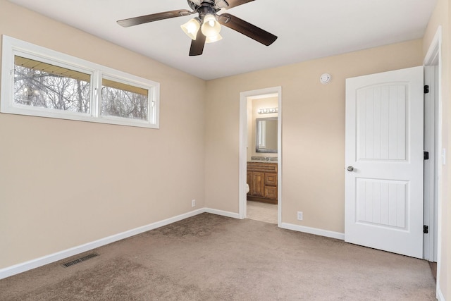 unfurnished bedroom featuring connected bathroom, ceiling fan, and light carpet