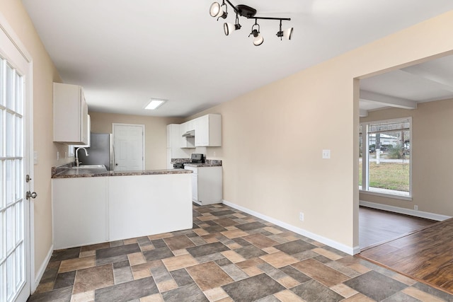 kitchen featuring beam ceiling, sink, kitchen peninsula, black range, and white cabinets