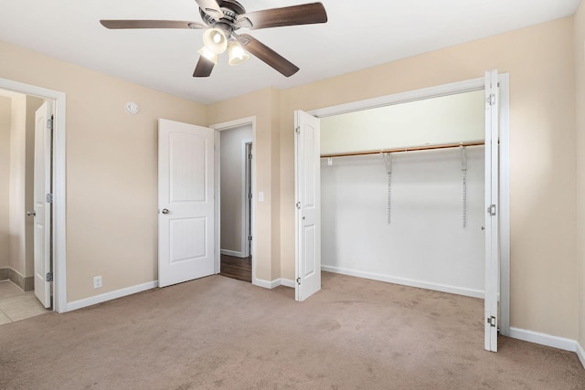 unfurnished bedroom featuring ceiling fan, light colored carpet, and a closet