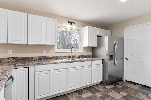 kitchen featuring white cabinets, stainless steel fridge, and sink