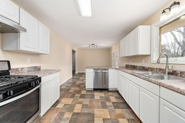 kitchen with white cabinets, stainless steel appliances, kitchen peninsula, and sink