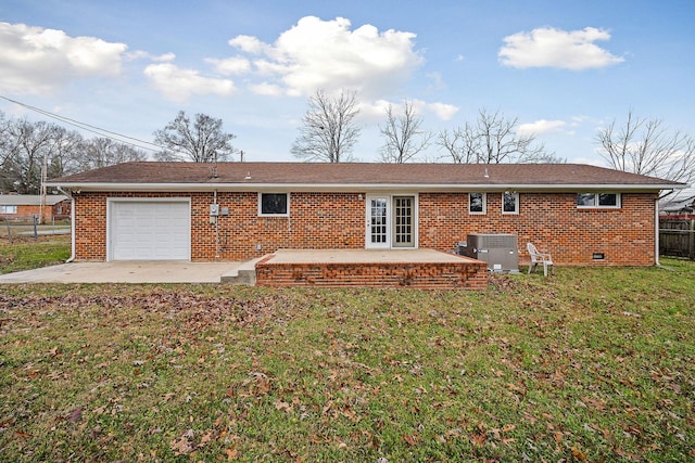 rear view of property with a yard, a patio, central AC, and a garage