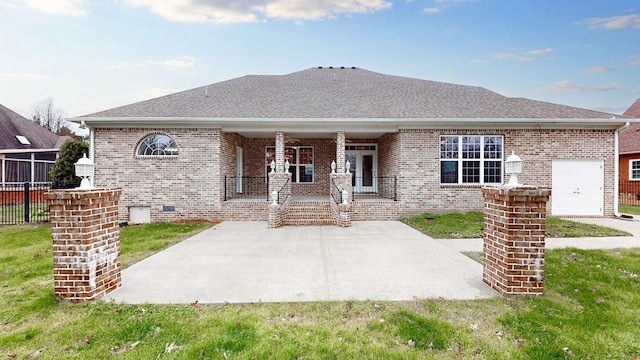 view of front of property featuring a patio, covered porch, brick siding, roof with shingles, and crawl space