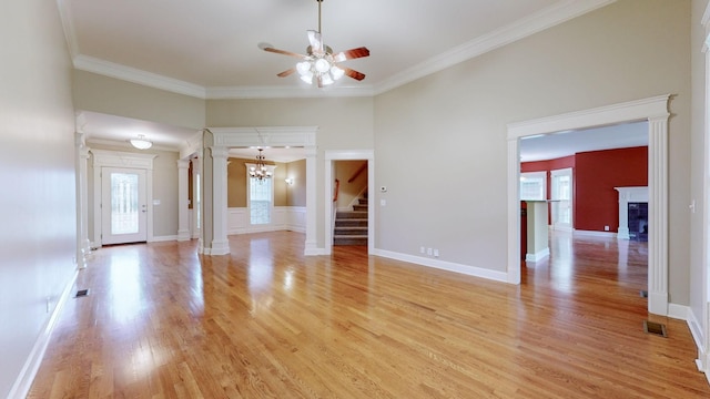 unfurnished living room with light wood-style floors, a fireplace, decorative columns, and ornamental molding