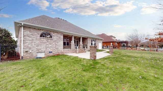 back of property featuring a patio area, fence, a lawn, and brick siding