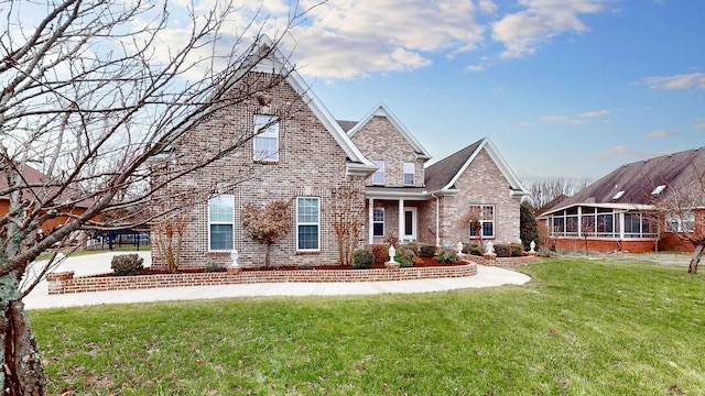 view of front of property featuring a sunroom and a front lawn