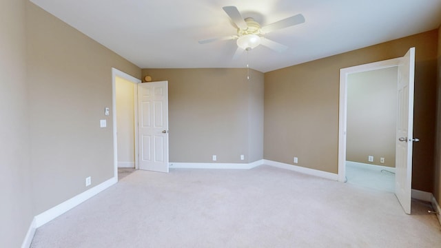 spare room with baseboards, a ceiling fan, and light colored carpet