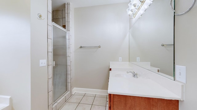 full bathroom with a stall shower, tile patterned flooring, vanity, and baseboards