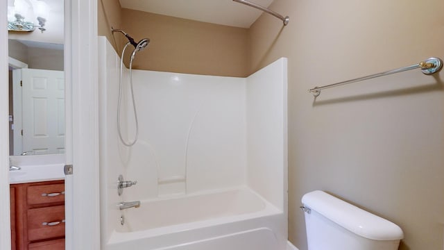 bathroom featuring toilet, vanity, and shower / bathtub combination