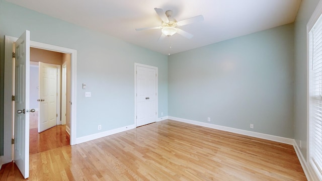 spare room with light wood-style floors, baseboards, and a ceiling fan