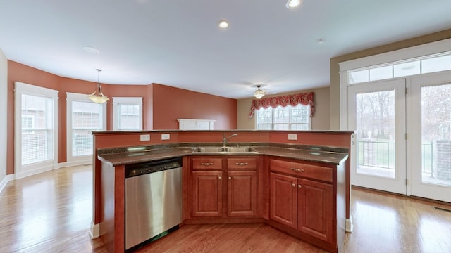 kitchen featuring a kitchen island with sink, a sink, hanging light fixtures, dishwasher, and brown cabinetry