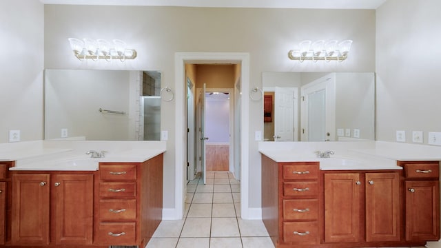 full bath featuring a shower stall, two vanities, a sink, and tile patterned floors