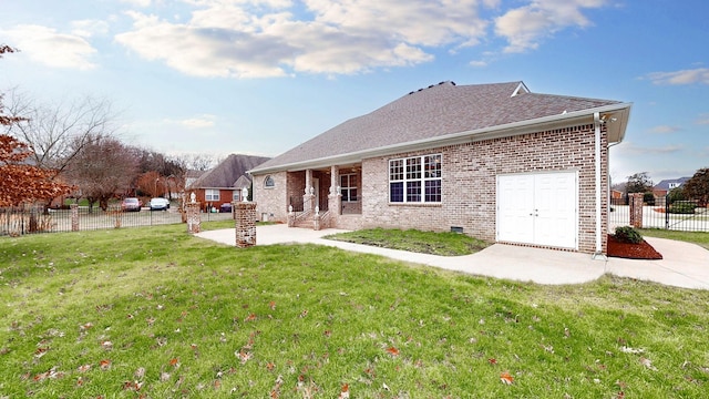 back of property featuring a yard, brick siding, a shingled roof, and fence