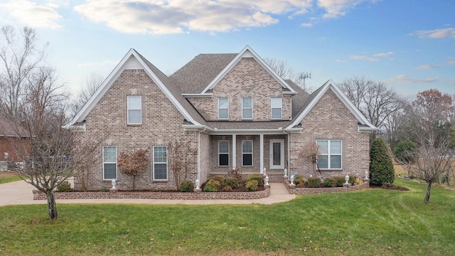 craftsman-style house featuring a front yard and brick siding