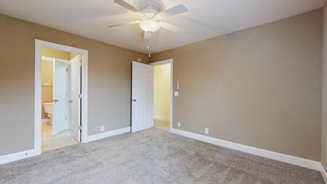 unfurnished bedroom with ensuite bath, ceiling fan, baseboards, and light colored carpet