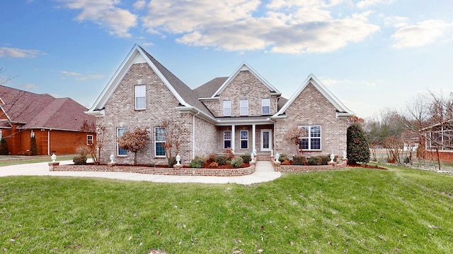 view of front of home featuring brick siding and a front yard