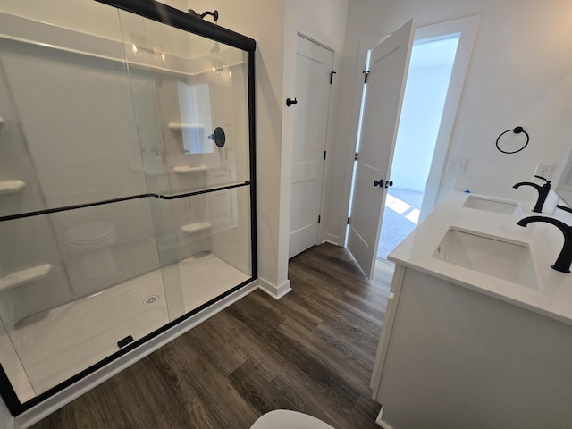 bathroom with vanity, toilet, hardwood / wood-style floors, and a shower with shower door