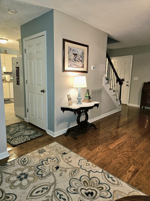 hall featuring a textured ceiling and hardwood / wood-style flooring