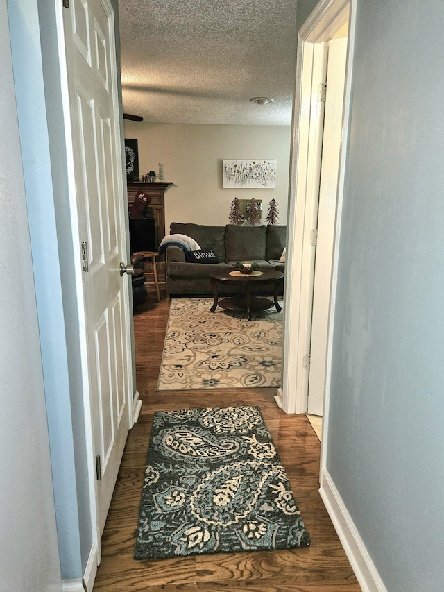 corridor featuring dark hardwood / wood-style floors and a textured ceiling