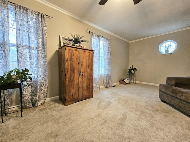 sitting room featuring ceiling fan, crown molding, light colored carpet, and a textured ceiling