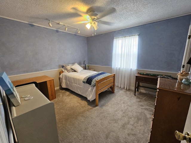 carpeted bedroom featuring rail lighting, ceiling fan, and a textured ceiling