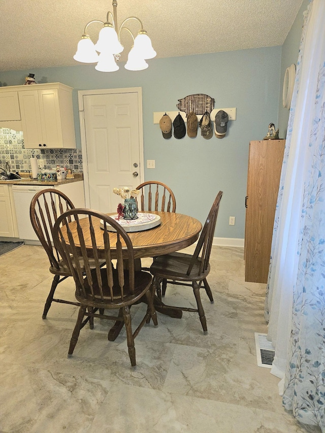 dining area featuring a textured ceiling and a notable chandelier