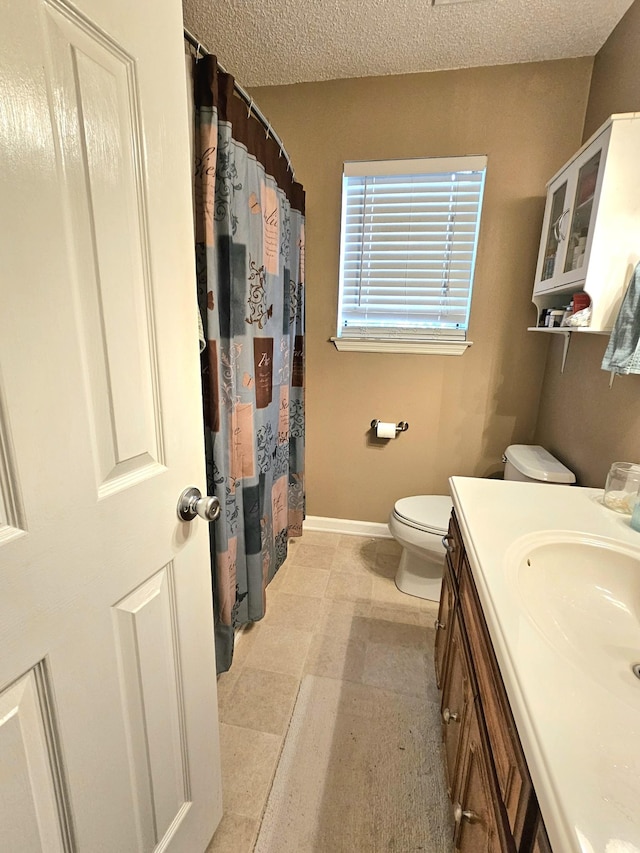 bathroom with vanity, a textured ceiling, and toilet