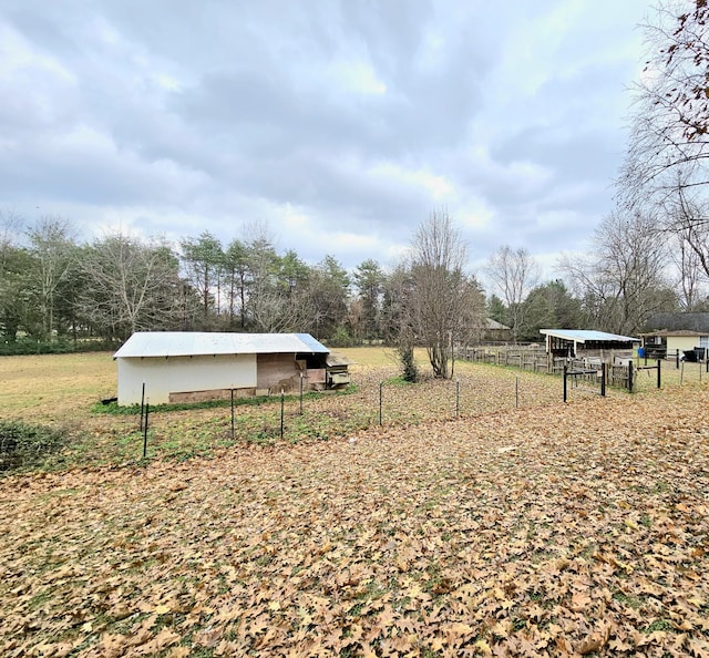 view of yard featuring a rural view and an outbuilding