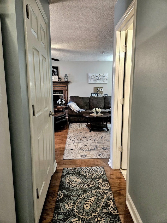 hall with dark hardwood / wood-style flooring and a textured ceiling