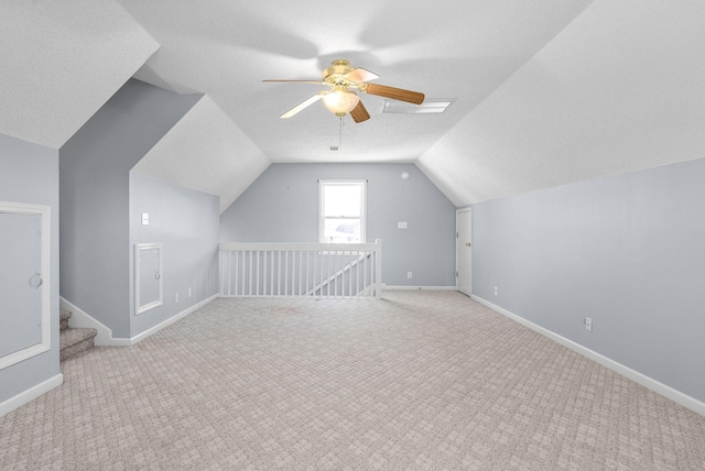 bonus room with vaulted ceiling, light colored carpet, ceiling fan, and a textured ceiling