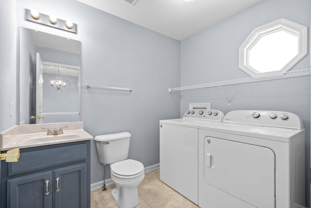 bathroom featuring tile patterned floors, toilet, a textured ceiling, vanity, and washing machine and dryer