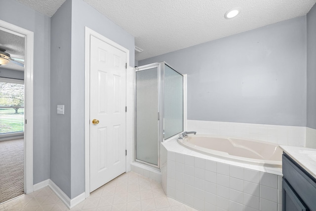 bathroom featuring vanity, independent shower and bath, and a textured ceiling