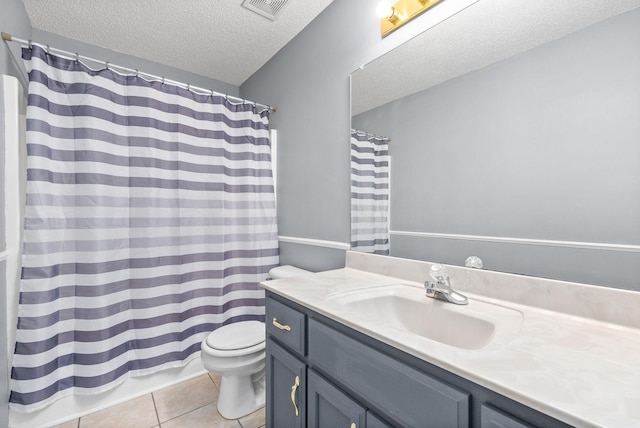 bathroom featuring vanity, toilet, tile patterned flooring, and a textured ceiling