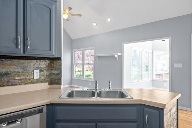 kitchen featuring blue cabinets, tasteful backsplash, lofted ceiling, sink, and stainless steel dishwasher