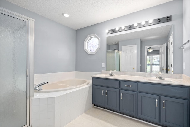 bathroom featuring vanity, separate shower and tub, and a textured ceiling