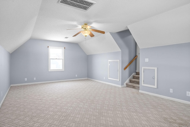 bonus room featuring light carpet, ceiling fan, lofted ceiling, and a textured ceiling