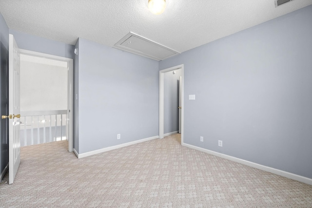 unfurnished room with light carpet and a textured ceiling